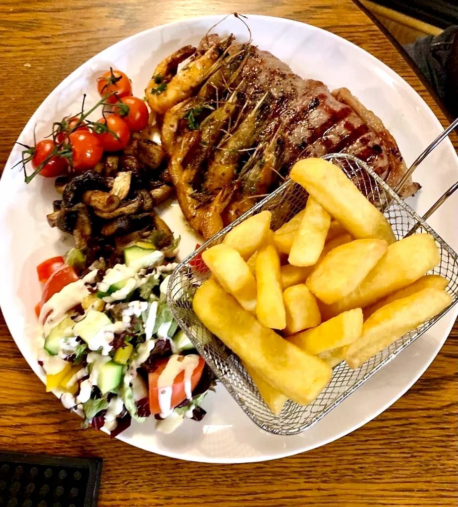 Sirloin steak with chips, grilled tomatoes and salad at The Broad Oak